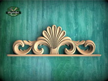 Load image into Gallery viewer, A decorative wooden carving with a stylized shell-like design is displayed against a teal-colored background.

