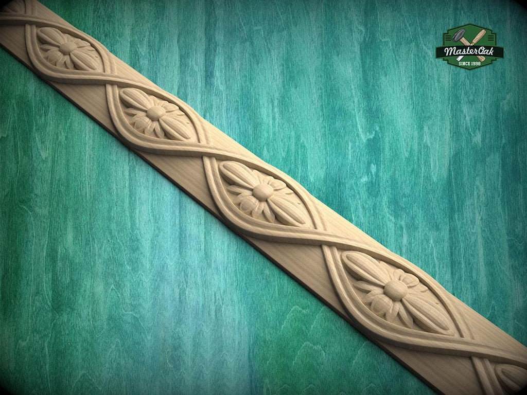 A decorative wooden border with intricate floral designs carved into it, set against a green wooden background.