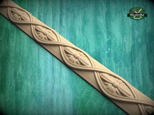 Load image into Gallery viewer, A decorative wooden border with intricate floral designs carved into it, set against a green wooden background.
