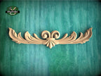 a wood carving of an ornate design on a green background