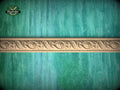 a decorative border made of carved wood, set against a green wooden background.