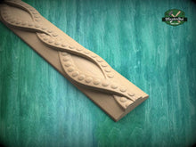 Load image into Gallery viewer, A wooden carving with a curved, organic design sits on a green wooden surface.
