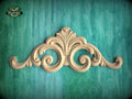 a decorative wooden carving on a teal background.