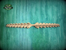 Load image into Gallery viewer, A decorative wooden leaf-like object is displayed against a green textured background.
