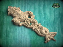 Load image into Gallery viewer, A decorative wooden carving with intricate floral and scrollwork designs is displayed against a green background.

