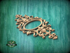 an ornate, carved wooden frame with intricate designs and patterns, set against a green wooden background.