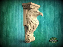 Load image into Gallery viewer, A carved wooden eagle head mounted on a wall, with a decorative scroll design around it.
