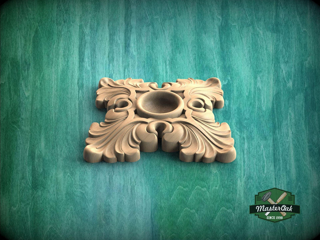 A decorative wooden piece with an ornate, floral design sits on a green textured background.