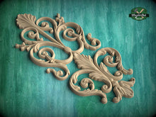 Load image into Gallery viewer, a decorative wooden carving with intricate scrollwork and floral elements, set against a teal background.
