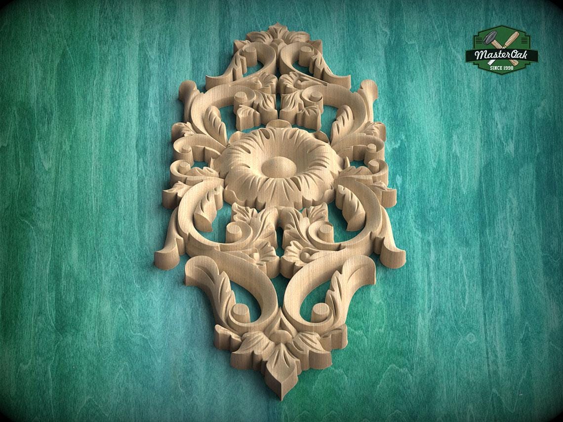 an ornate, carved wooden panel with intricate floral and leaf designs, set against a green background.