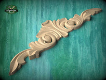 Load image into Gallery viewer, A wooden carving with an intricate, decorative design is displayed against a green background.
