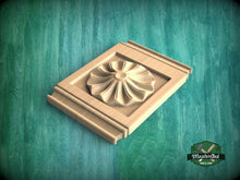 Load image into Gallery viewer, A wooden carving of a flower-like design is displayed on a wooden surface against a green background.
