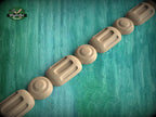 A row of wooden objects, possibly carved or shaped, arranged in a linear fashion against a green background.