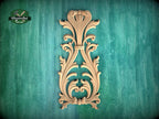 a decorative wooden carving on a green background.