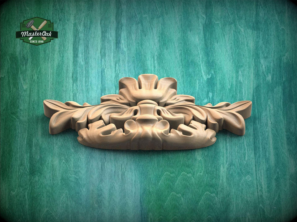 A wooden carving of a stylized face or sculpture is displayed against a green background.