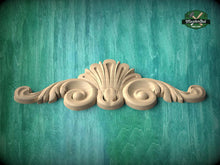 Load image into Gallery viewer, A decorative wooden carving with a stylized design is displayed against a teal-colored background.
