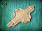 a wooden carving with intricate designs, placed on a green wooden surface.
