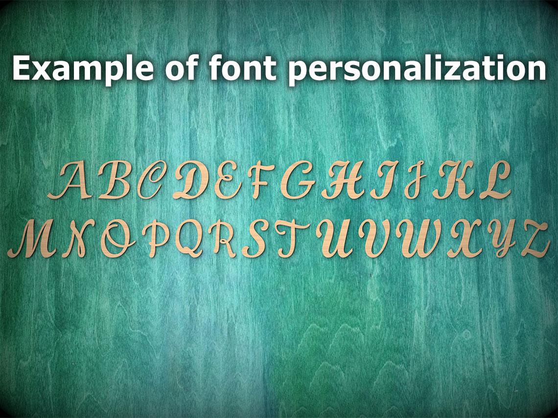 a close-up view of a wooden surface with a greenish-blue background. The text "Example of font personalization" is written above the image, and the letters "A" through "Z" are shown in a cursive font, suggesting a personalized font or design.