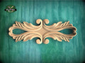 a decorative wooden carving on a green background.