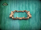 A decorative wooden frame with an ornate, curving design is displayed against a green textured background.
