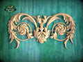 a decorative wooden carving with intricate floral and leaf-like patterns, set against a green background.