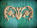 a decorative wooden carving with intricate floral and leaf-like patterns, set against a green background.