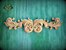 Load image into Gallery viewer, a decorative wooden carving with intricate scrollwork and floral elements, set against a textured green background.
