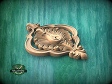 Load image into Gallery viewer, A wooden carving of a decorative leaf or flower design is displayed against a green background.
