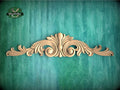 a wood carving of an ornate design on a green background