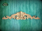 a wood carving of an ornate design on a green background