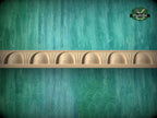 a wooden shelf with a curved design, set against a textured green background.