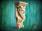 A carved stone sculpture of a bearded, horned figure with an intense expression, mounted on a green wooden background.