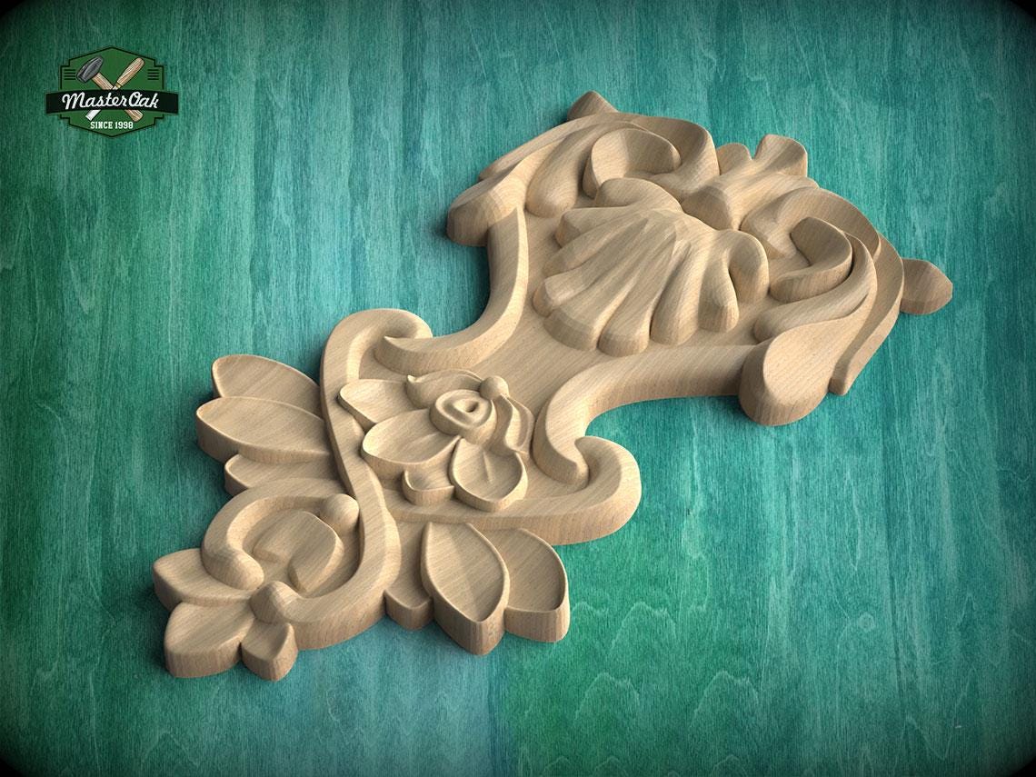A wooden carving with intricate floral and leaf designs is displayed against a green background.