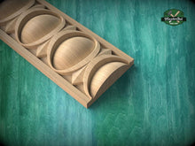 Load image into Gallery viewer, A wooden carving with a geometric pattern is displayed against a green background.
