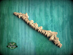 a wood carving of a floral design on a green background