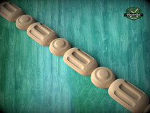 Load image into Gallery viewer, A row of wooden objects, possibly carved or shaped, arranged in a linear fashion against a green background.
