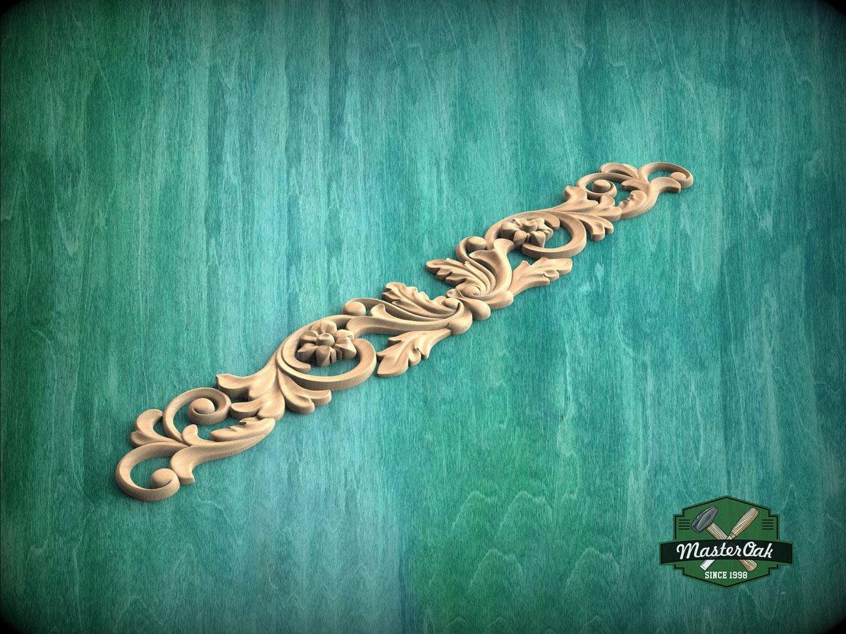 A decorative wooden carving with intricate floral and scrollwork designs is displayed against a green textured background.