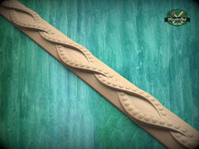 Load image into Gallery viewer, A decorative wooden border with a repeating pattern of curved lines and circular shapes, set against a green wooden background.
