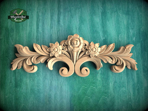 a wooden carving of flowers and leaves on a green background