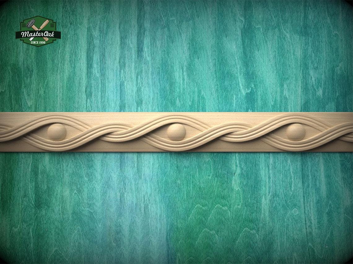 a decorative border made of wood, with a wavy pattern and circular elements, set against a green textured background.