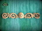 a wooden carving of a flower on a green background