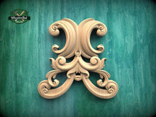 Load image into Gallery viewer, an ornate, carved wooden piece with intricate scrollwork and floral designs, set against a green background.
