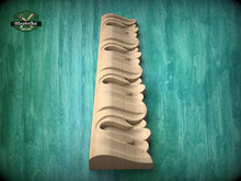 Load image into Gallery viewer, A wooden carving of a decorative element, possibly a decorative trim or molding, is displayed against a green background.
