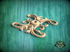 A decorative wooden carving in the shape of a flower or leaf, placed on a green textured background.