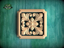 Load image into Gallery viewer, a square wooden carving with an intricate floral design, set against a green background.
