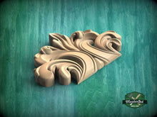 Load image into Gallery viewer, A wooden carving with an intricate, swirling design is displayed against a green background.
