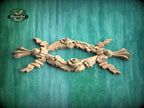 A wooden carving with intricate floral designs is displayed against a green background.