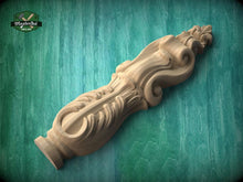 Load image into Gallery viewer, A wooden carving with intricate designs is displayed against a green background.
