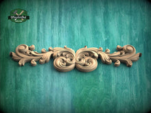 Load image into Gallery viewer, A decorative wooden carving with intricate scrollwork is displayed against a green textured background.
