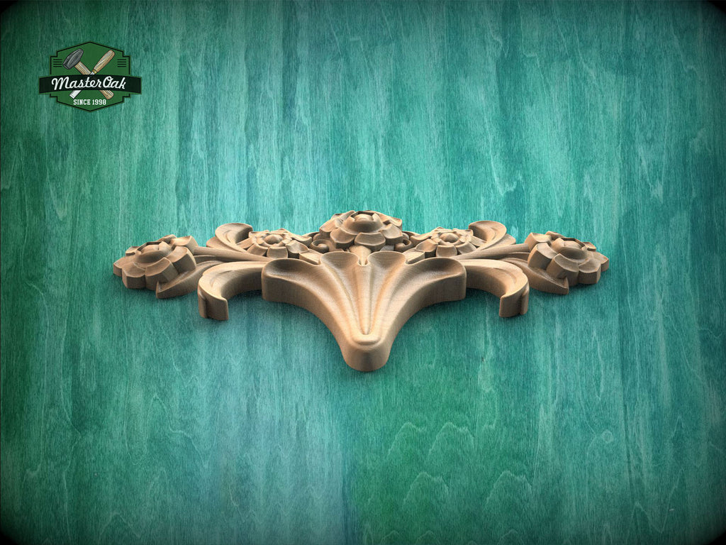 A decorative wooden carving with a floral design is displayed against a green wooden background.